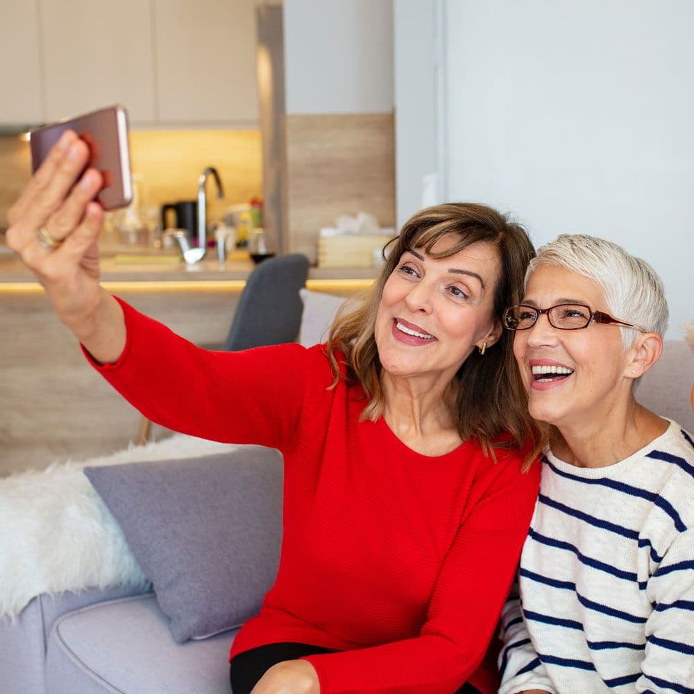 A group of older adults smiling and taking a selfie